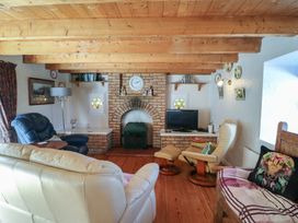 A living room with a fireplace and television at Fuschia Cottage, Waterville, County Kerry