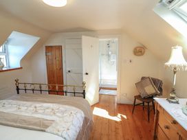 A bedroom with a bed and a shower at Fuschia Cottage, Waterville, County Kerry