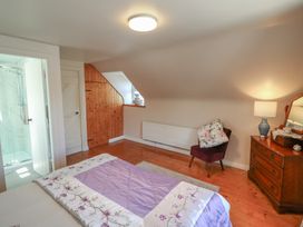 A bedroom with a bed and bathroom in Fuschia Cottage Waterville, County Kerry