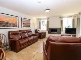 A living room with sofas, a fireplace, and a television at Mill Lodge in Brisley