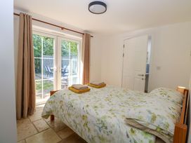 A bedroom with a bed and patio doors at Mill Lodge in Brisley