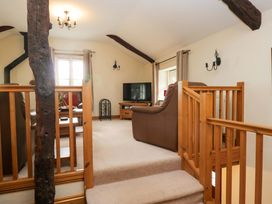A living room with a television and sofa at Copper Beech Cottage in Torver