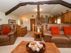 A living room with sofas and a wooden table at Copper Beech Cottage in Torver