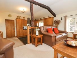 A living room with a sofa and wooden furniture at Copper Beech Cottage in Torver