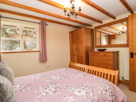 A bedroom with a bed and wardrobe at Copper Beech Cottage in Torver