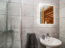 A bathroom with a sink and shower at Copper Beech Cottage in Torver