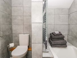 A bathroom with a toilet and towels on a rack at Copper Beech Cottage in Torver