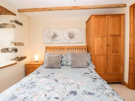 A bedroom with a bed and wardrobe at Copper Beech Cottage in Torver