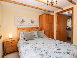 A bedroom with a bed and a wardrobe at Copper Beech Cottage in Torver