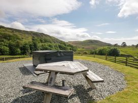 An outdoor area with a hot tub and a picnic table at Copper Beech Cottage in Torver