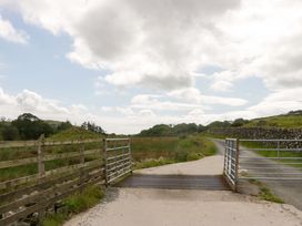A view of a gate and gravel road at Copper Beech Cottage in Torver