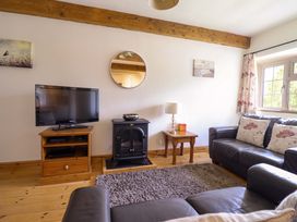 A living room with a television and a fireplace at Stabal Cottage in Dolgellau