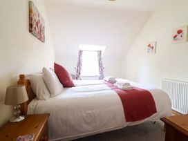 A bedroom with a bed and window at Stabal Cottage in Dolgellau