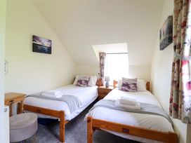 A bedroom with two beds and a window at Stabal Cottage in Dolgellau