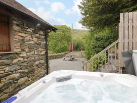 An outdoor area with a hot tub and a picnic table at Yew Tree Cottage Torver