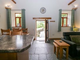 A living room with a door leading outside at Yew Tree Cottage in Torver