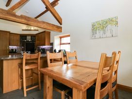 A kitchen with wooden furniture at Yew Tree Cottage in Torver