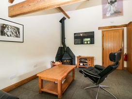 A living room with a fireplace and furniture at Yew Tree Cottage in Torver