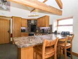 A kitchen with wooden cabinets and an island at Yew Tree Cottage in Torver