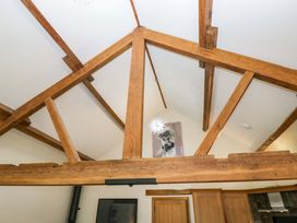 A view of wooden beams and light fixture in a living room at Yew Tree Cottage in Torver