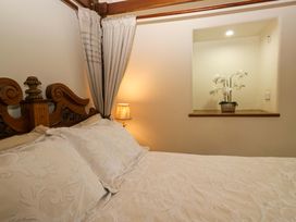 A bedroom with a bed and a lamp at Yew Tree Cottage in Torver