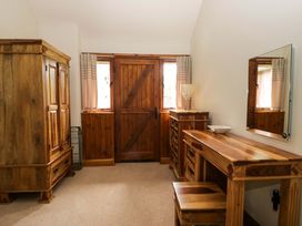A bedroom with wooden furniture at Yew Tree Cottage in Torver