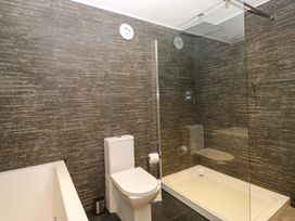 A bathroom with a bathtub and shower at Yew Tree Cottage in Torver