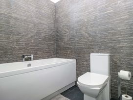 A bathroom with a bathtub and toilet at Yew Tree Cottage in Torver