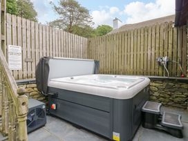 An outdoor hot tub with a sign and steps at Yew Tree Cottage in Torver