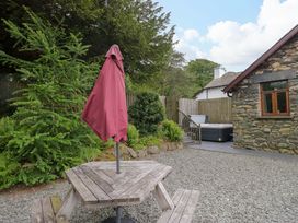 An outdoor space with a table and umbrella at Yew Tree Cottage in Torver
