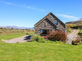 A house with a driveway and grass surrounding it at Stone Cottage in Waterville, County Kerry
