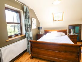 A bedroom with a bed and nightstands at Stone Cottage in Waterville, County Kerry