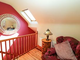 A landing with a lamp and armchair at Stone Cottage in Waterville, County Kerry