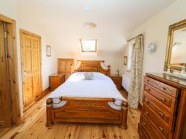 A bedroom with a bed and wooden furniture at Stone Cottage in Waterville, County Kerry