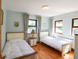 A bedroom with two beds and a lamp at Stone Cottage in Waterville, County Kerry
