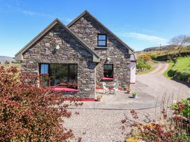 A stone house with a table and chairs outside at Stone Cottage in Waterville, County Kerry