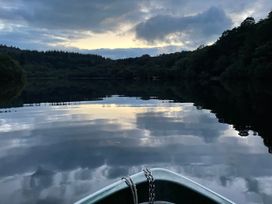 A lake with reflections and a boat at Tafarn Trip in Tan Y Bwlch, Maentwrog