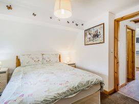 A bedroom with a double bed butterflies on bedding and wall art of horses at Glan Nug Bach in Rhydlydan near Betws-y-Coed