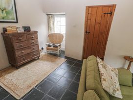 A living room with a chest of drawers, a rocking chair, and a sofa at Swallows St Keverne, Lizard Peninsula