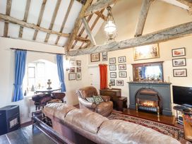 A living room with leather sofas a fireplace framed pictures and wooden beams at St Marys Tal y Llyn near Dolgellau