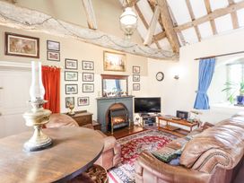 A living room with leather sofas a fireplace a TV and framed pictures on the wall at St.Marys Tal y Llyn near Dolgellau