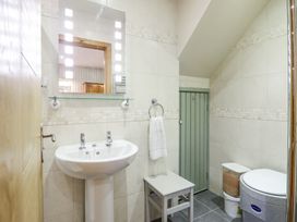 A bathroom with a pedestal sink mirror stool and waste bin at St.Marys in Tal y Llyn near Dolgellau