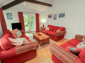 A living room with red sofas and a coffee table at Winster Fields in Cartmel Fell near Windermere