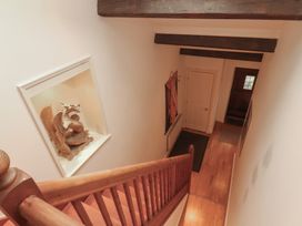 A staircase leading to the hallway with a dragon sculpture at Winster Fields Cartmel Fell near Windermere