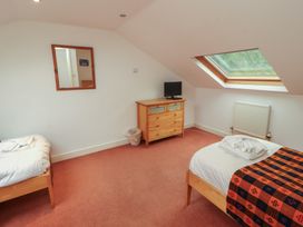 A bedroom with two beds and a dresser at Winster Fields in Cartmel Fell near Windermere