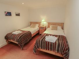 A bedroom with two beds and a nightstand at Winster Fields Cartmel Fell near Windermere