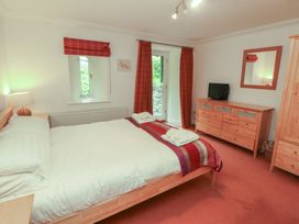 A bedroom with a double bed and furniture at Winster Fields in Cartmel Fell near Windermere
