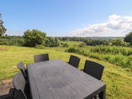An outdoor dining set on grass with trees in the background at Winster Fields in Cartmel Fell near Windermere