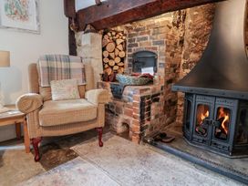 A living room with an armchair and fireplace at Church Farmhouse in Winsham