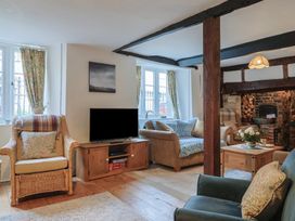 A living room with a television and seating at Church Farmhouse in Winsham